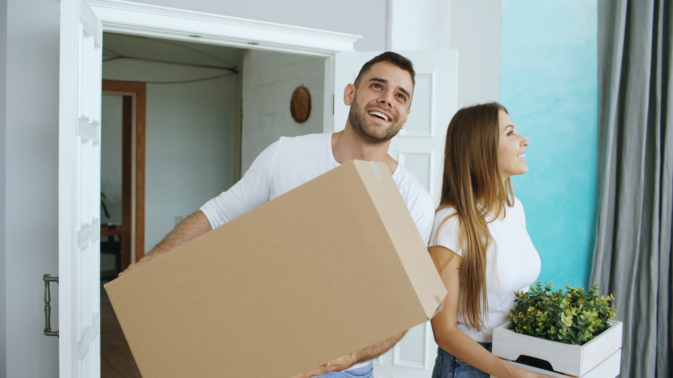 young couple moving boxes into their new home